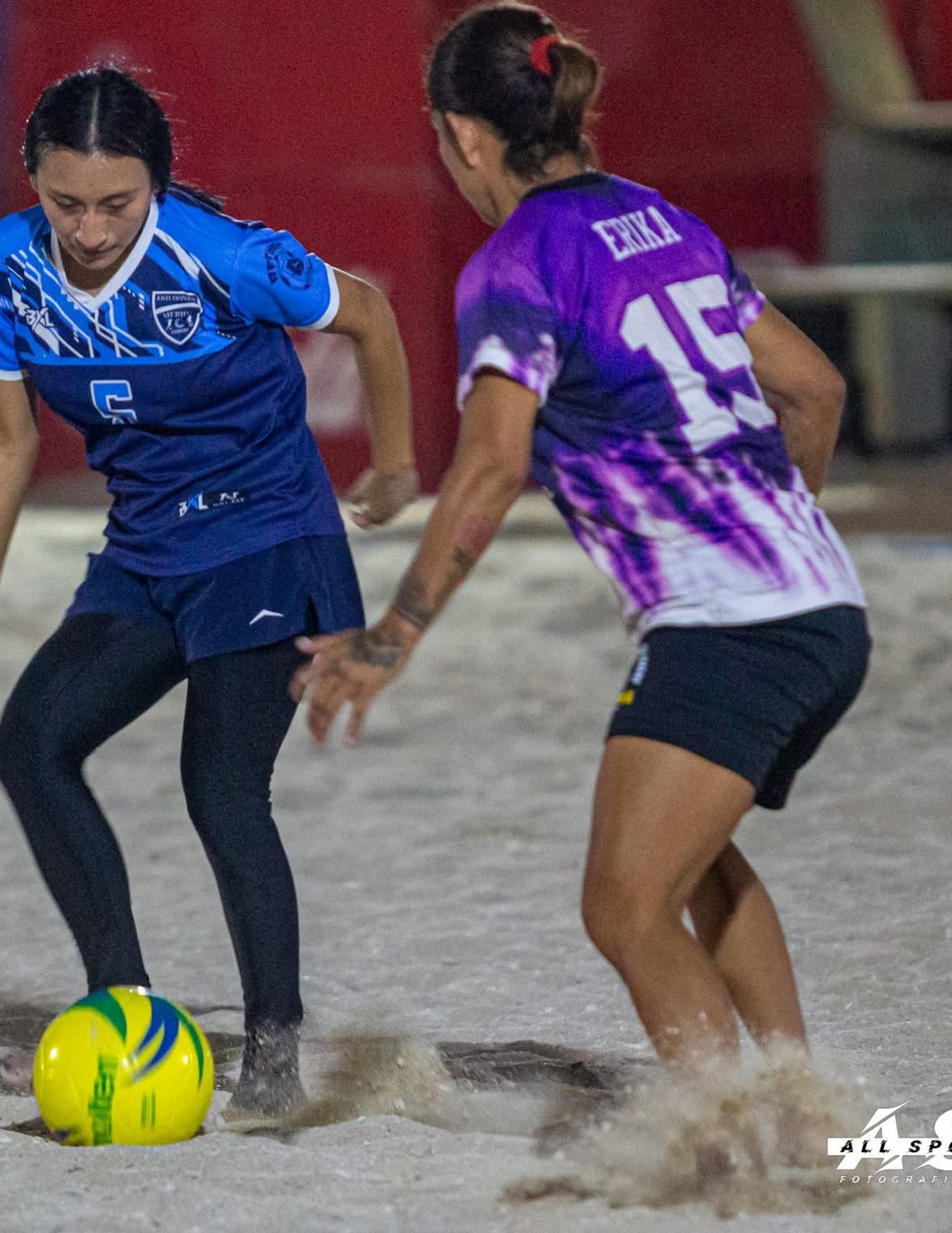 Partido de fútbol playa en acción con jugadores usando uniformes BXL